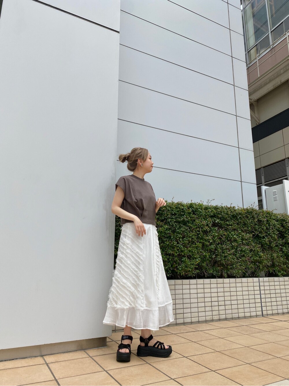 ブラック系のサンダル、ホワイト系のスカート、ベージュ系のタンクトップを着用したレディースの夏コーディネートの2枚目の写真