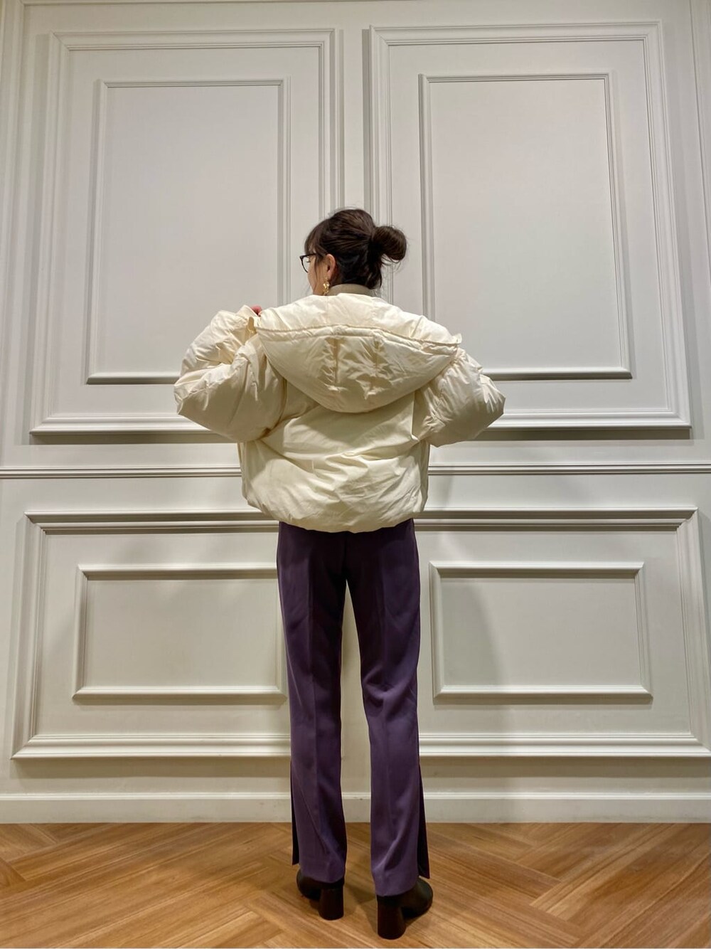 ホワイト系のダウンジャケット/コート、ブラック系のブーツ、パープル系のその他パンツを着用したレディースの秋コーディネートの2枚目の写真