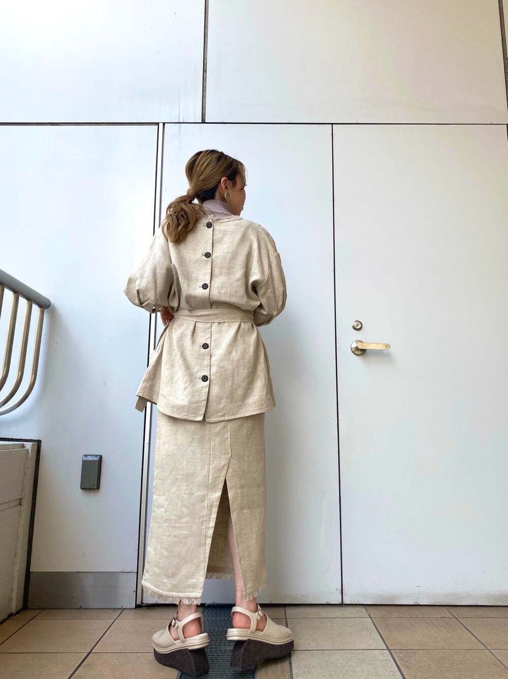 ホワイト系のスカート、ホワイト系のサンダル、ホワイト系のテーラードジャケットを着用したレディースの春コーディネートの3枚目の写真