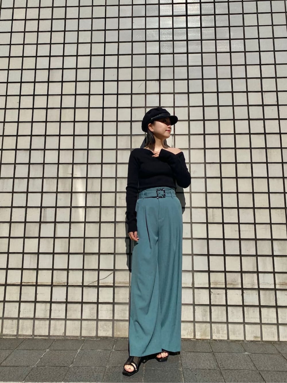 ブラック系のニット/セーター、グリーン系のその他パンツ、ブラック系のブーツを着用したレディースの冬コーディネートの2枚目の写真