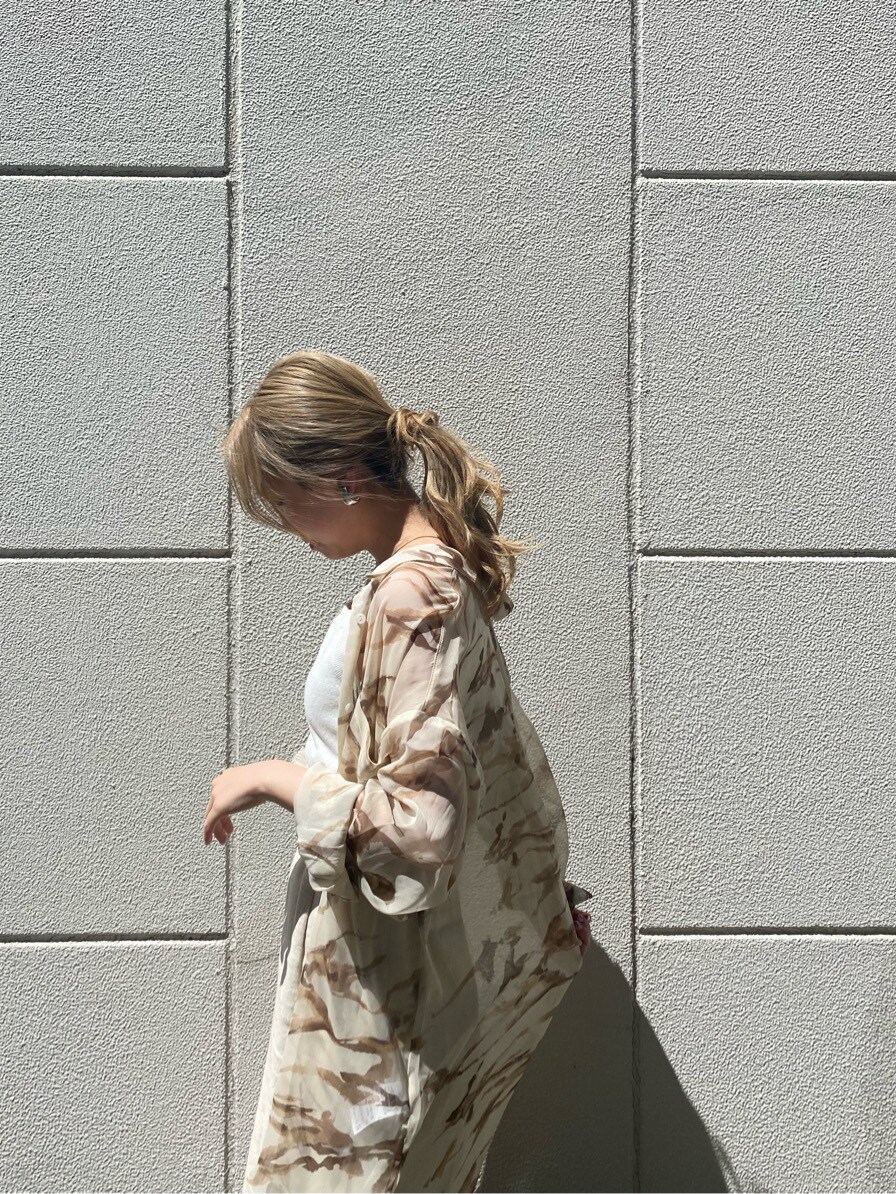 ホワイト系のスカート、ホワイト系のニット/セーター、ホワイト系のサンダルを着用したレディースの春コーディネートの2枚目の写真