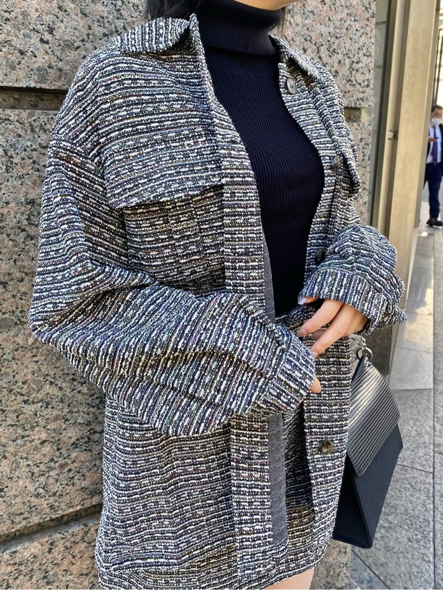 ブラック系のブーツ、ブラック系のスカート、ブラック系のハンドバッグを着用したレディースの冬コーディネートの5枚目の写真