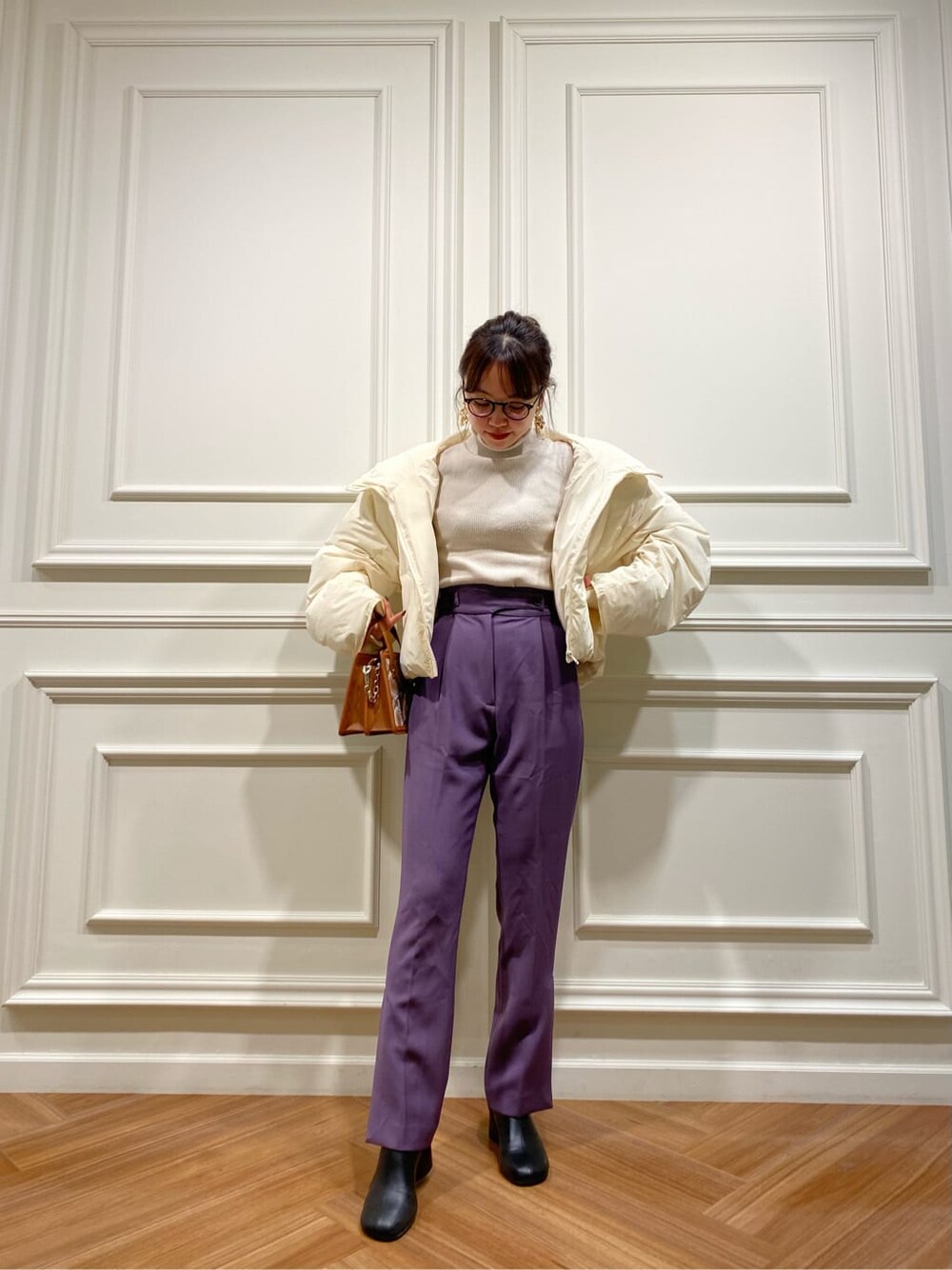 ホワイト系のダウンジャケット/コート、ブラック系のブーツ、パープル系のその他パンツを着用したレディースの秋コーディネートの4枚目の写真