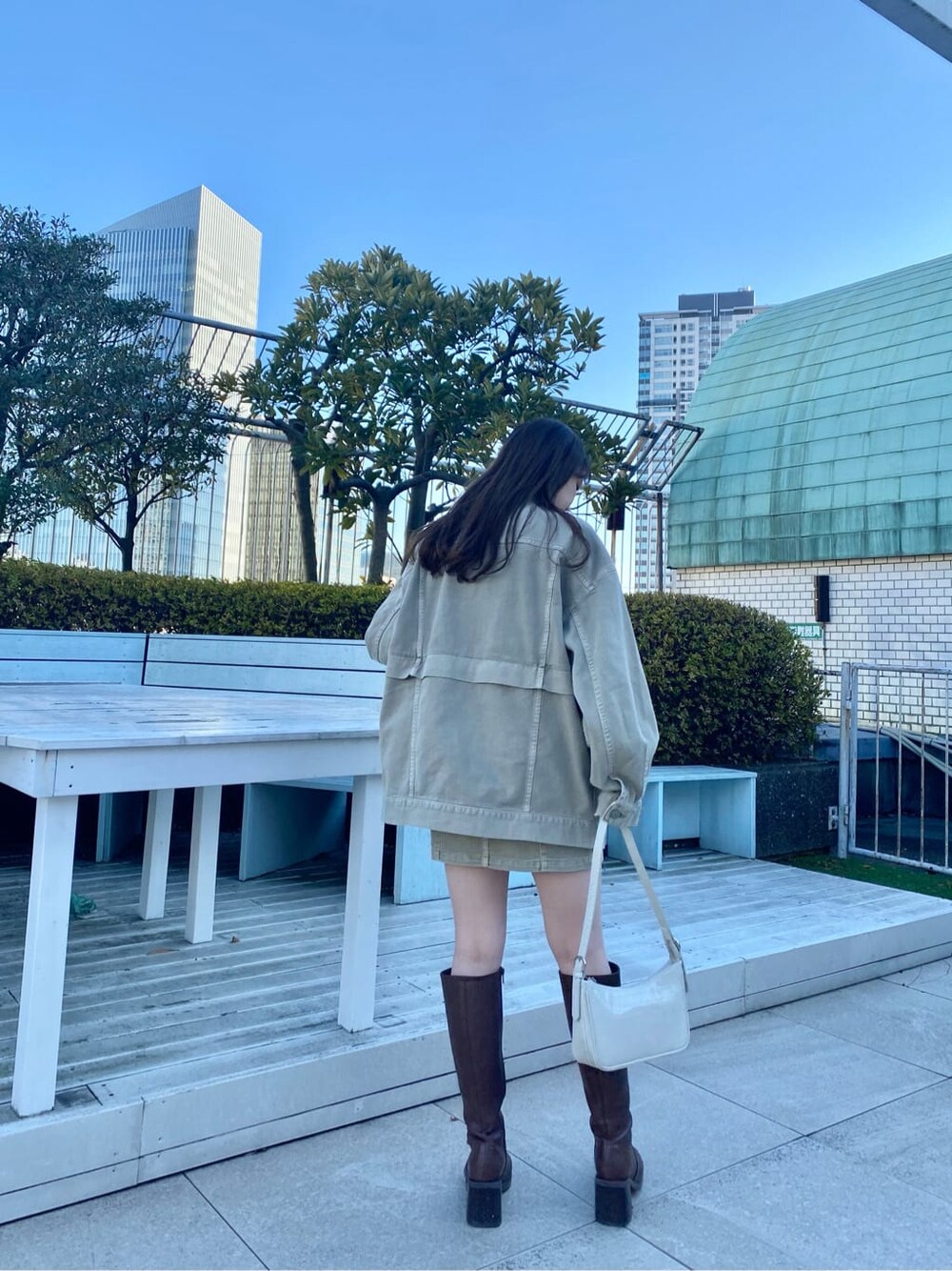 ブラウン系のブーツ、ホワイト系のニット/セーター、ベージュ系のデニムジャケットを着用したレディースの冬コーディネートの2枚目の写真