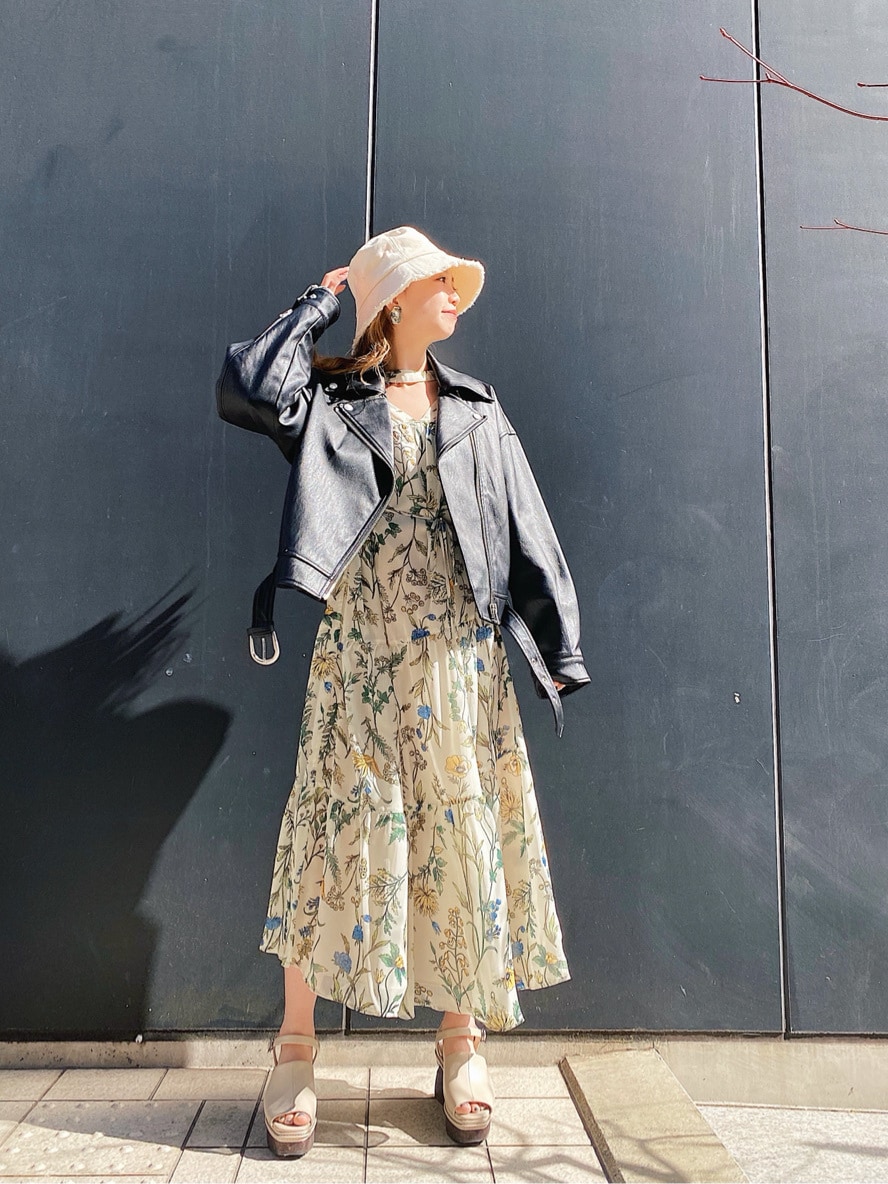 ベージュ系のワンピース、ブラック系のライダースジャケット、ホワイト系のサンダルを着用したレディースの春コーディネートの3枚目の写真