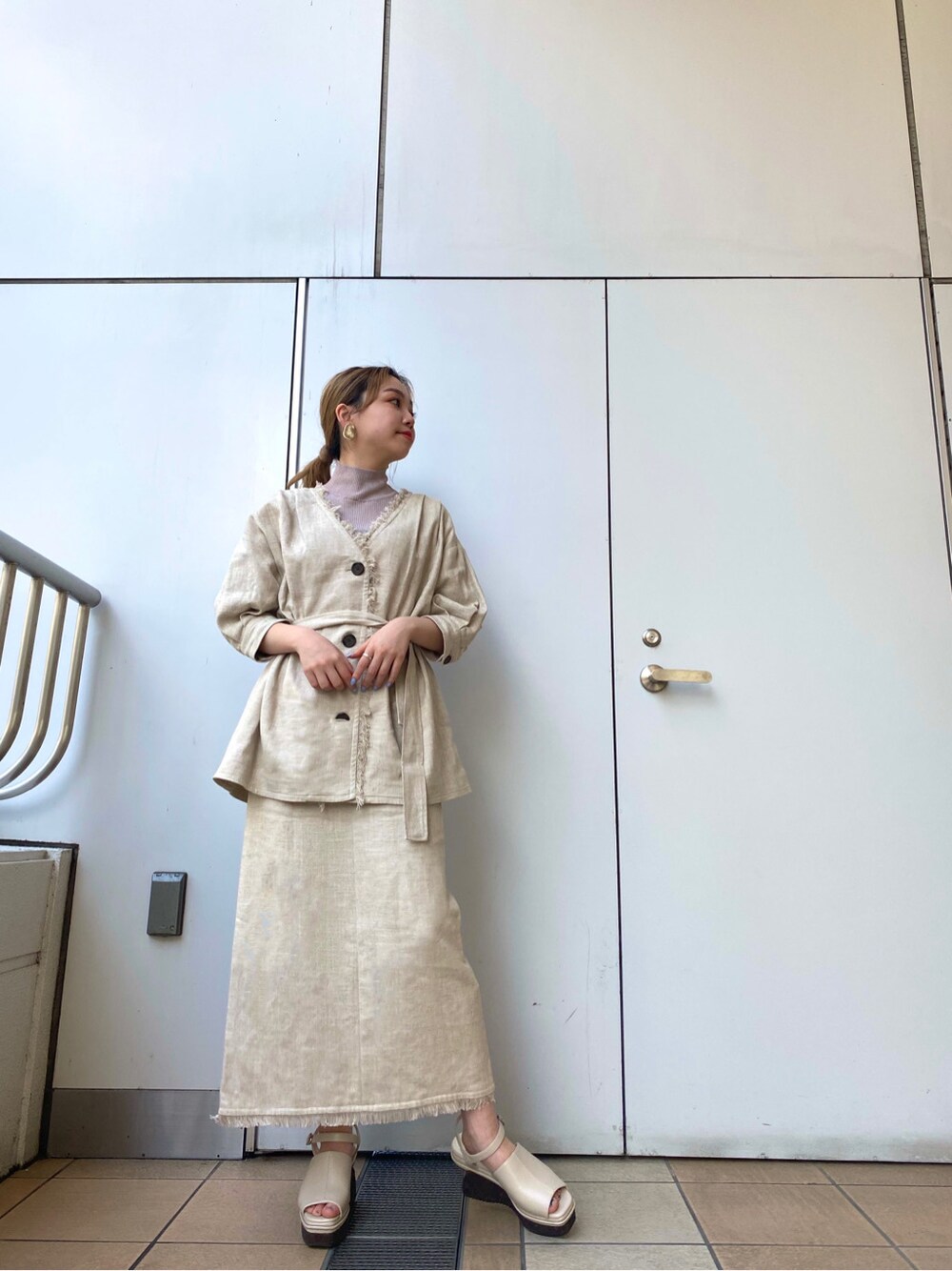 ホワイト系のスカート、ホワイト系のサンダル、ホワイト系のテーラードジャケットを着用したレディースの春コーディネートの2枚目の写真