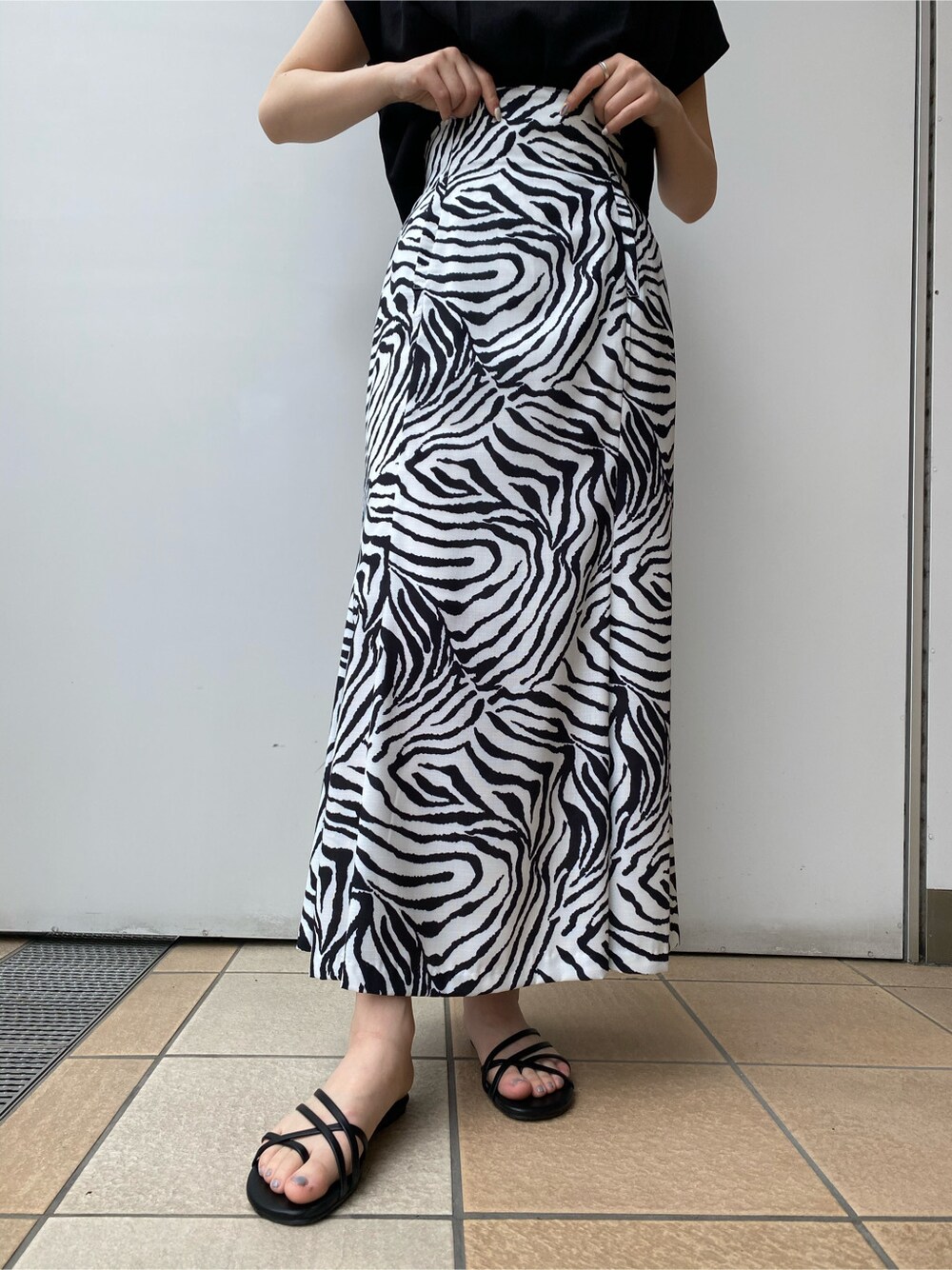 ブラック系のサンダル、その他のスカート、ブラック系のタンクトップを着用したレディースの夏コーディネートの3枚目の写真