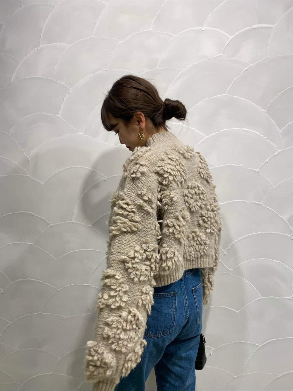 ブラック系のブーツ、ブルー系のデニムパンツ、ホワイト系のニット/セーターを着用したレディースの秋コーディネートの2枚目の写真