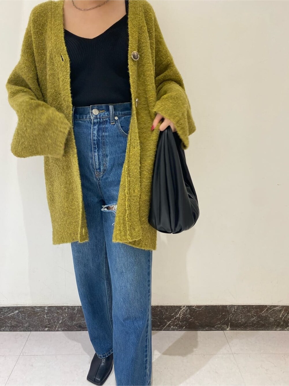 ブラック系のブーツ、ブルー系のデニムパンツ、ブルー系のデニムパンツを着用したレディースの秋コーディネートの3枚目の写真