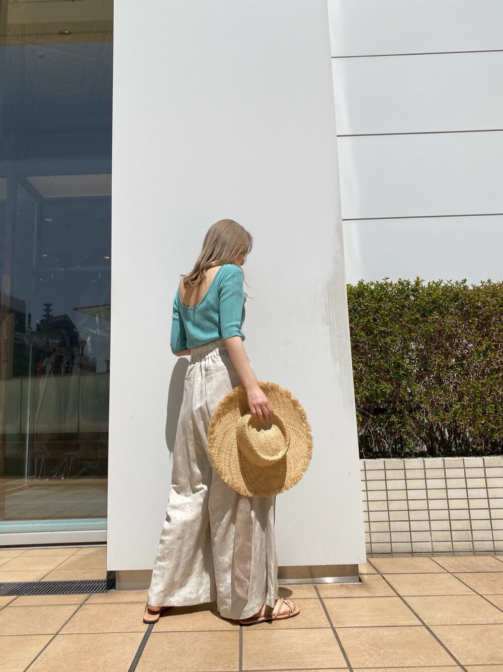 ホワイト系のその他パンツ、ブルー系のニット/セーター、ベージュ系のサンダルを着用したレディースの春コーディネートの2枚目の写真