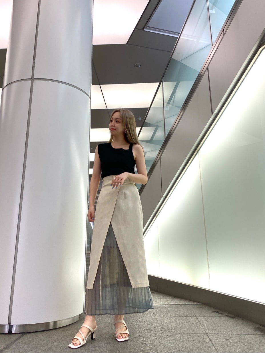 ホワイト系のスカート、ホワイト系のサンダル、ブラック系のニット/セーターを着用したレディースの春コーディネートの2枚目の写真