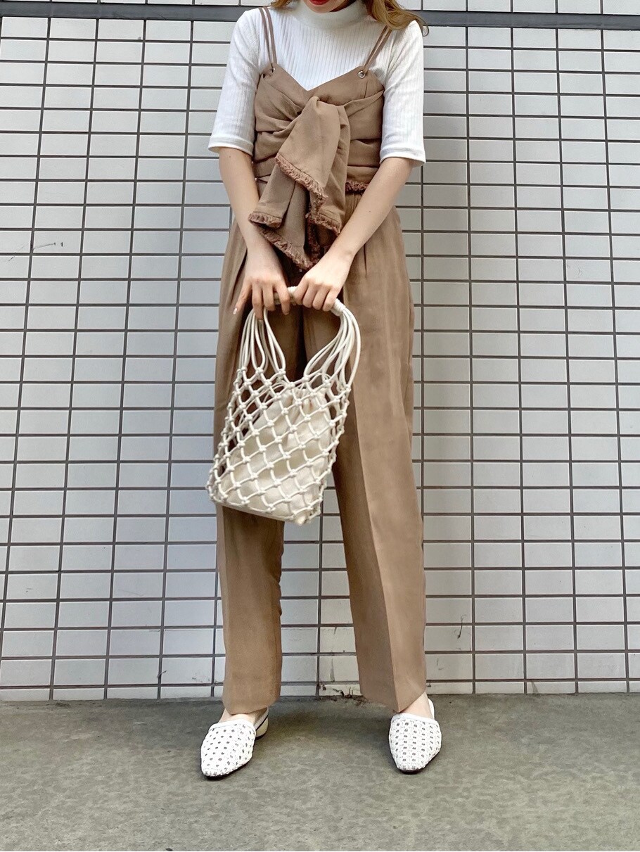 ベージュ系のTシャツ/カットソー、ベージュ系のスラックス、ホワイト系のサンダルを着用したレディースの春コーディネートの2枚目の写真