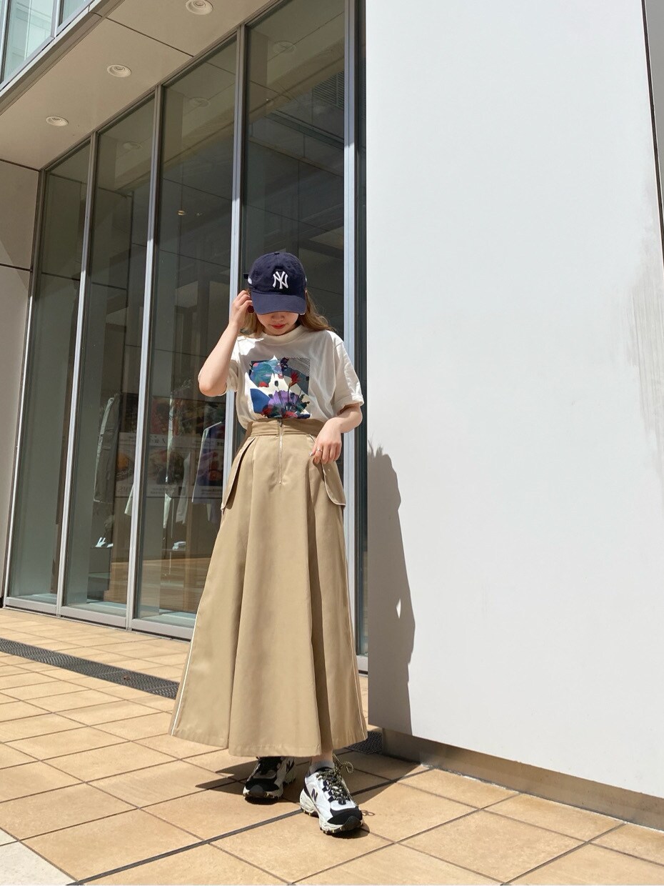ベージュ系のスカート、ホワイト系のTシャツ/カットソーを着用したレディースの春コーディネートの2枚目の写真