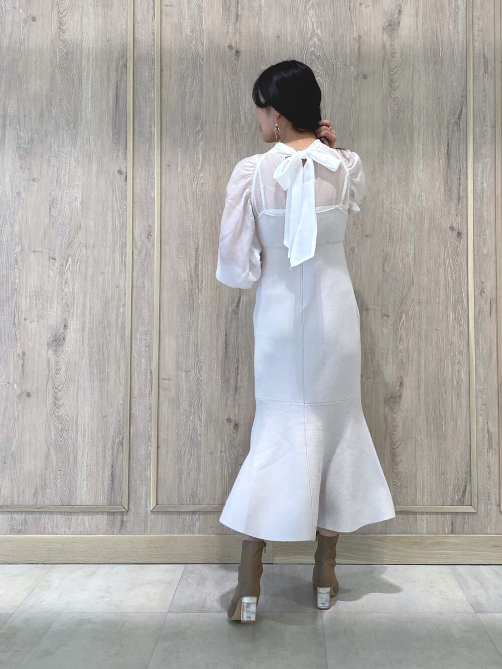 ベージュ系のブーツ、ホワイト系のワンピース、ホワイト系のチューブトップを着用したレディースの冬コーディネートの4枚目の写真