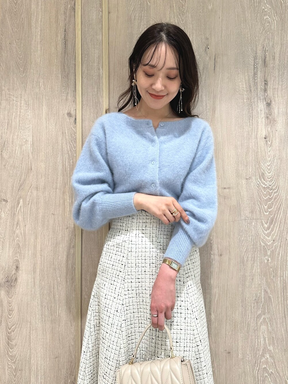 ホワイト系のスカート、ブルー系のカーディガン/ボレロ、ブラウン系のブーツを着用したレディースの秋コーディネートの5枚目の写真