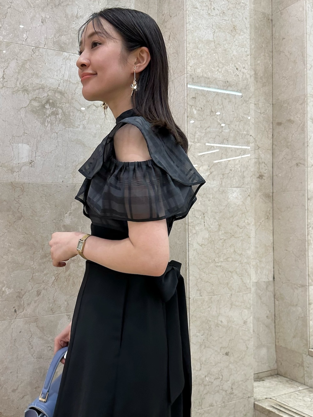 ブラック系のワンピース、ブルー系のハンドバッグ、その他のサンダルを着用したレディースの春コーディネートの6枚目の写真