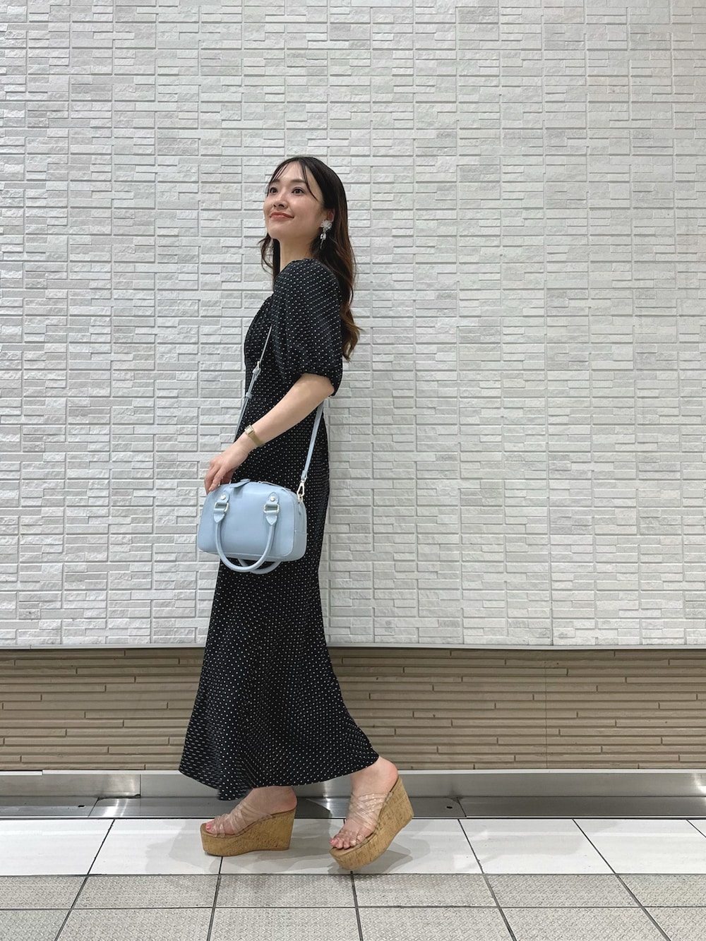 その他のサンダル、ブラック系のワンピース、ブルー系のボストンバッグを着用したレディースの夏コーディネートの2枚目の写真