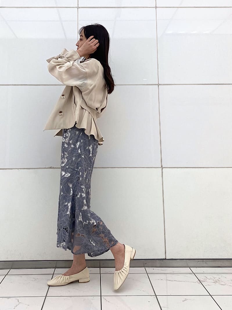 ホワイト系のTシャツ/カットソー、ベージュ系のトレンチコート、ホワイト系のパンプスを着用したレディースの春コーディネートの2枚目の写真