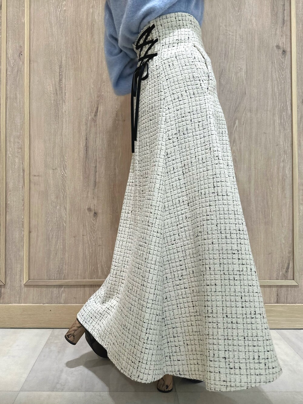 ホワイト系のスカート、ブルー系のカーディガン/ボレロ、ブラウン系のブーツを着用したレディースの秋コーディネートの9枚目の写真