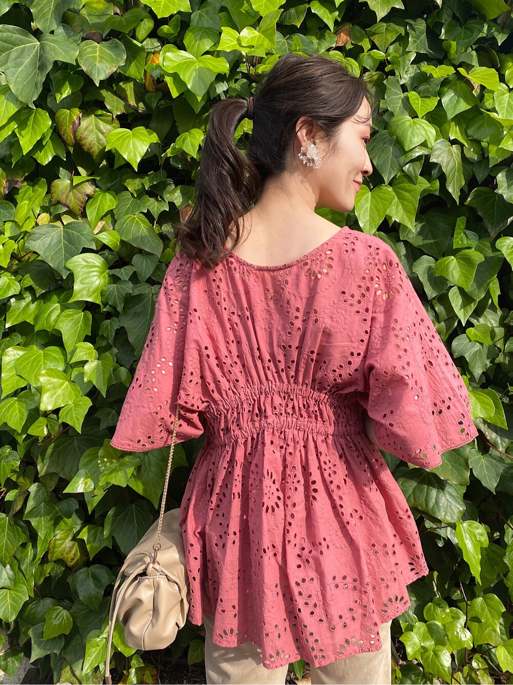 ベージュ系のその他パンツ、グリーン系のサンダル、ベージュ系のクラッチバッグを着用したレディースの春コーディネートの2枚目の写真