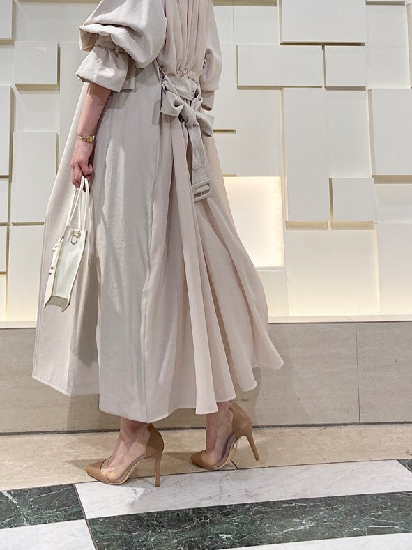 ベージュ系のパンプス、ベージュ系のトレンチコート、パープル系のワンピースを着用したレディースの春コーディネートの5枚目の写真