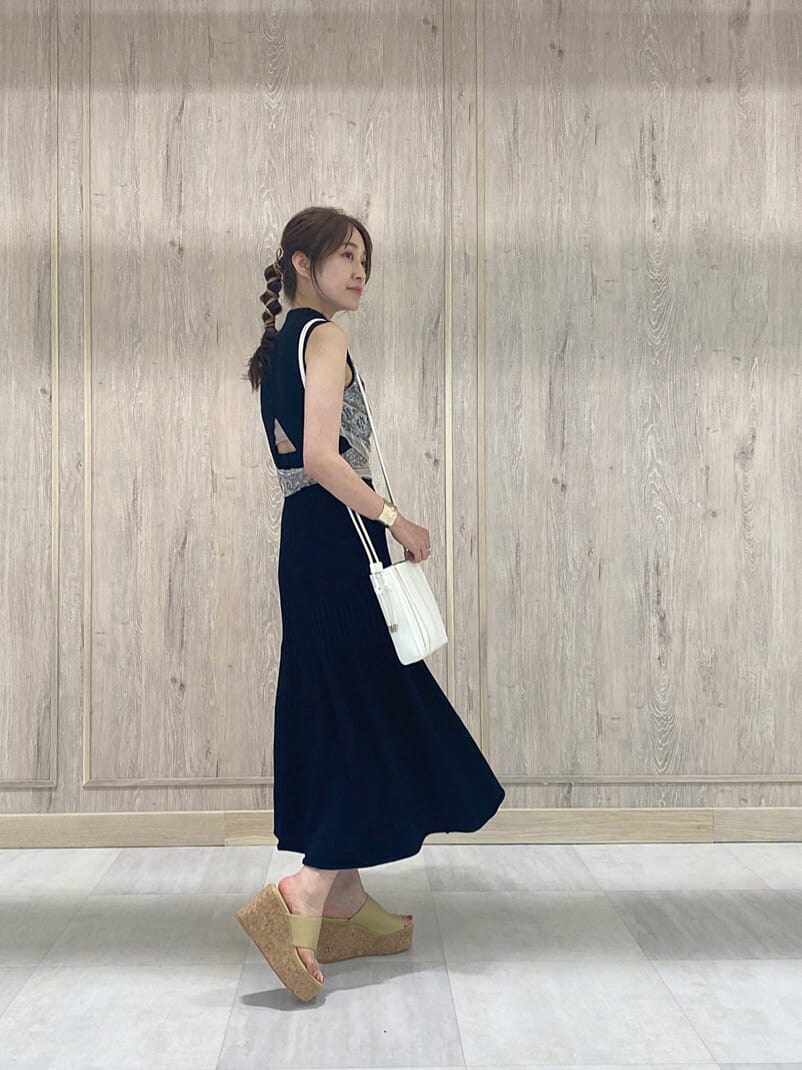 ブラック系のワンピース、イエロー系のサンダル、ホワイト系のハンドバッグを着用したレディースの夏コーディネートの2枚目の写真