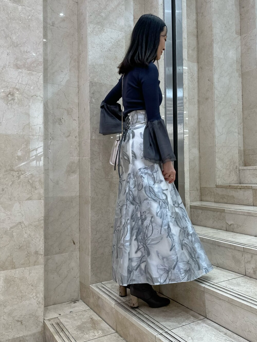 ブラウン系のブーツ、ピンク系のショルダーバッグ、グレー系のニット/セーターを着用したレディースの春コーディネートの3枚目の写真