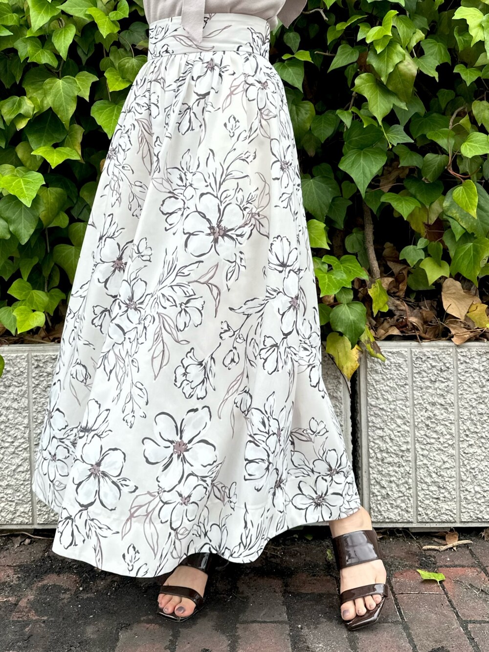 ブラウン系のサンダル、ホワイト系のスカート、ピンク系のニット/セーターを着用したレディースの夏コーディネートの7枚目の写真