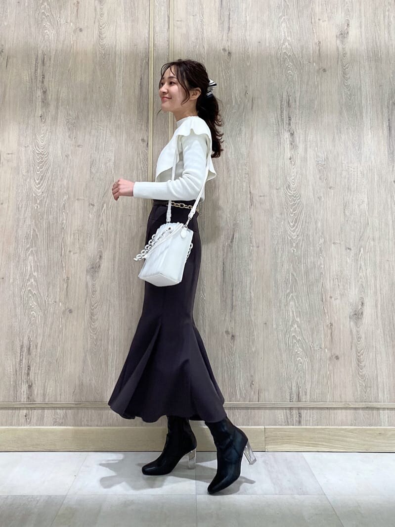 パープル系のスカート、ブラック系のその他シューズ、ホワイト系のニット/セーターを着用したレディースの冬コーディネートの2枚目の写真