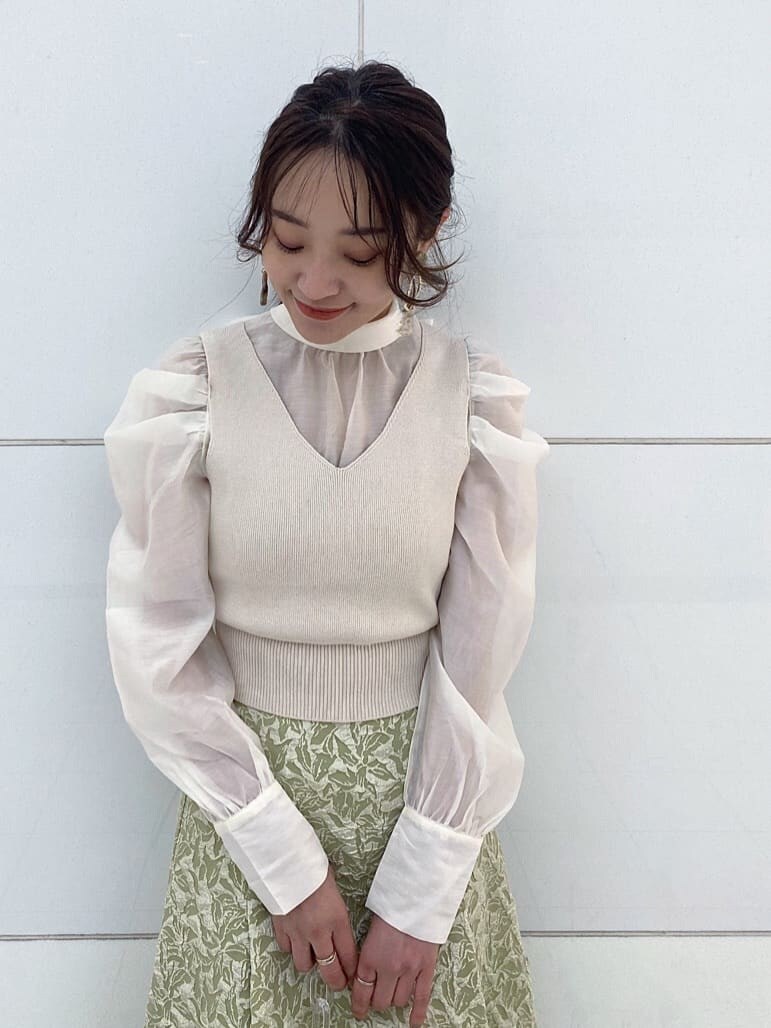 ベージュ系のパンプス、グリーン系のスカート、イエロー系のショルダーバッグを着用したレディースの冬コーディネートの6枚目の写真