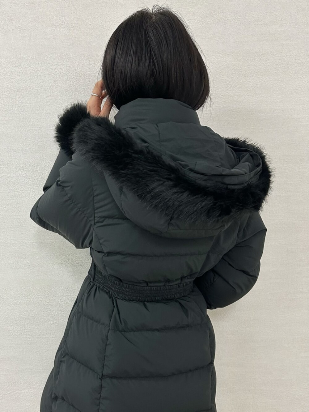 グリーン系のワンピース、ブラウン系のブーツ、ブラック系のダウンジャケット/コートを着用したレディースの冬コーディネートの10枚目の写真