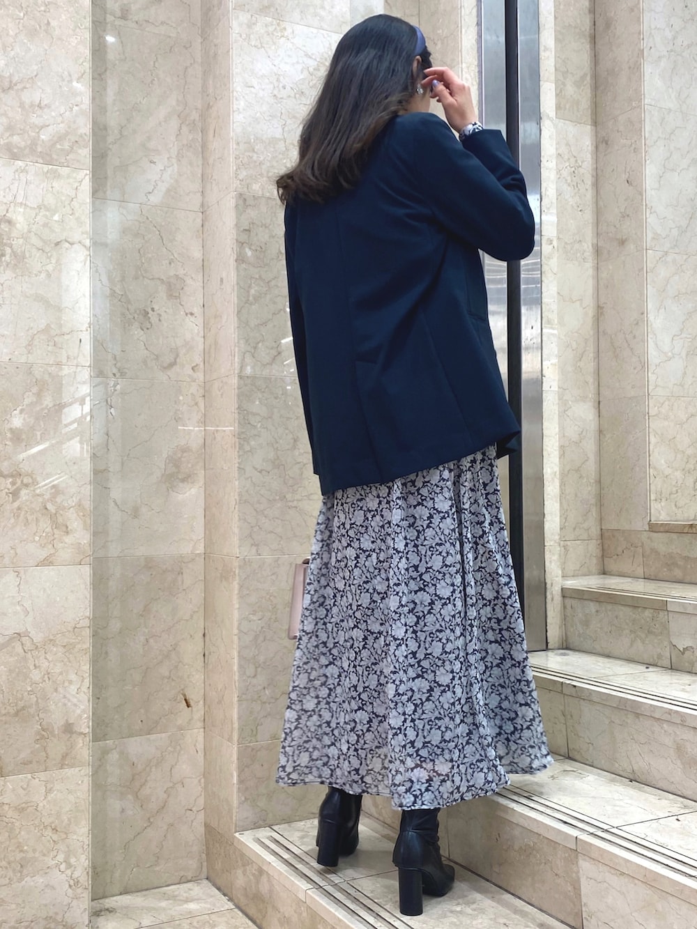 ブラック系のワンピース、ブラック系のブーツ、ブルー系のテーラードジャケットを着用したレディースの冬コーディネートの4枚目の写真