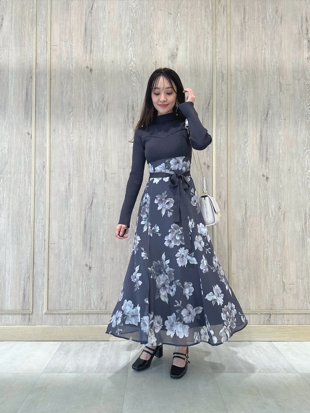 ピンク系のショルダーバッグ、ブラウン系のパンプス、パープル系のワンピースを着用したレディースの秋コーディネートの2枚目の写真