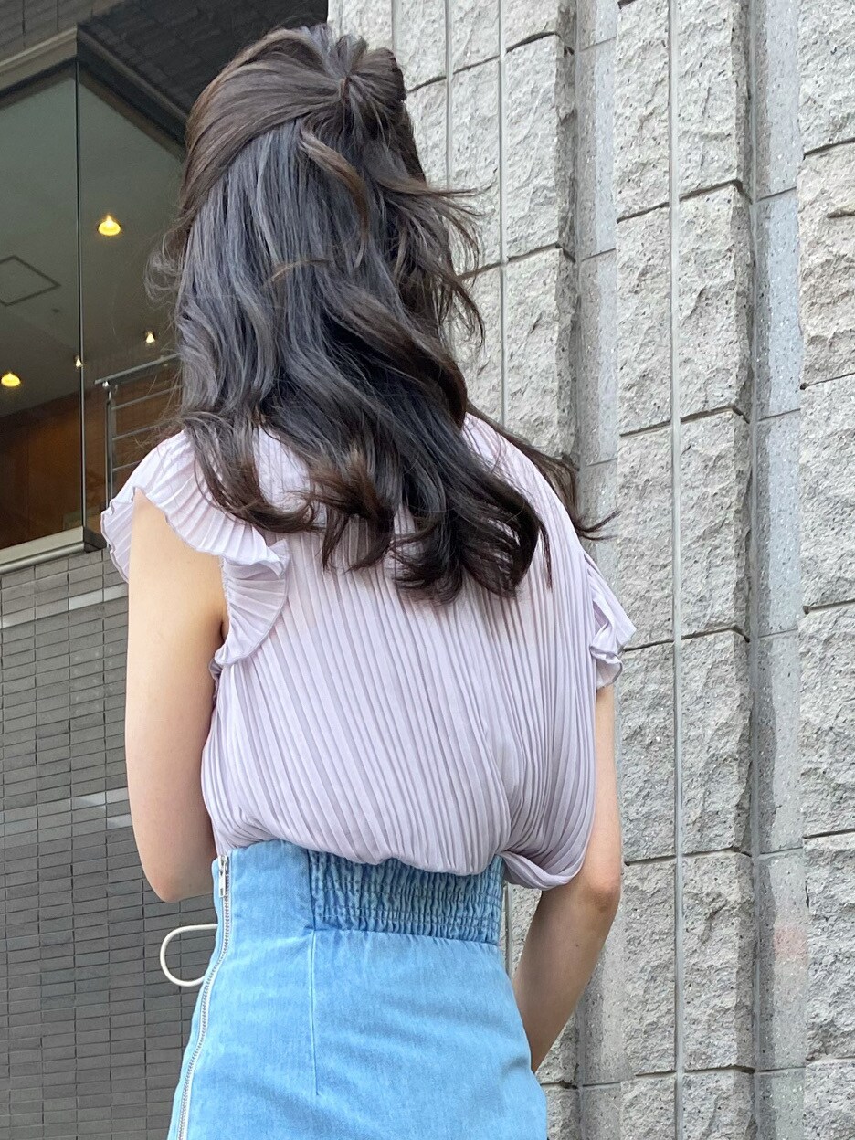 ベージュ系のクラッチバッグ、ホワイト系のサンダル、ブルー系のスカートを着用したレディースの春コーディネートの6枚目の写真