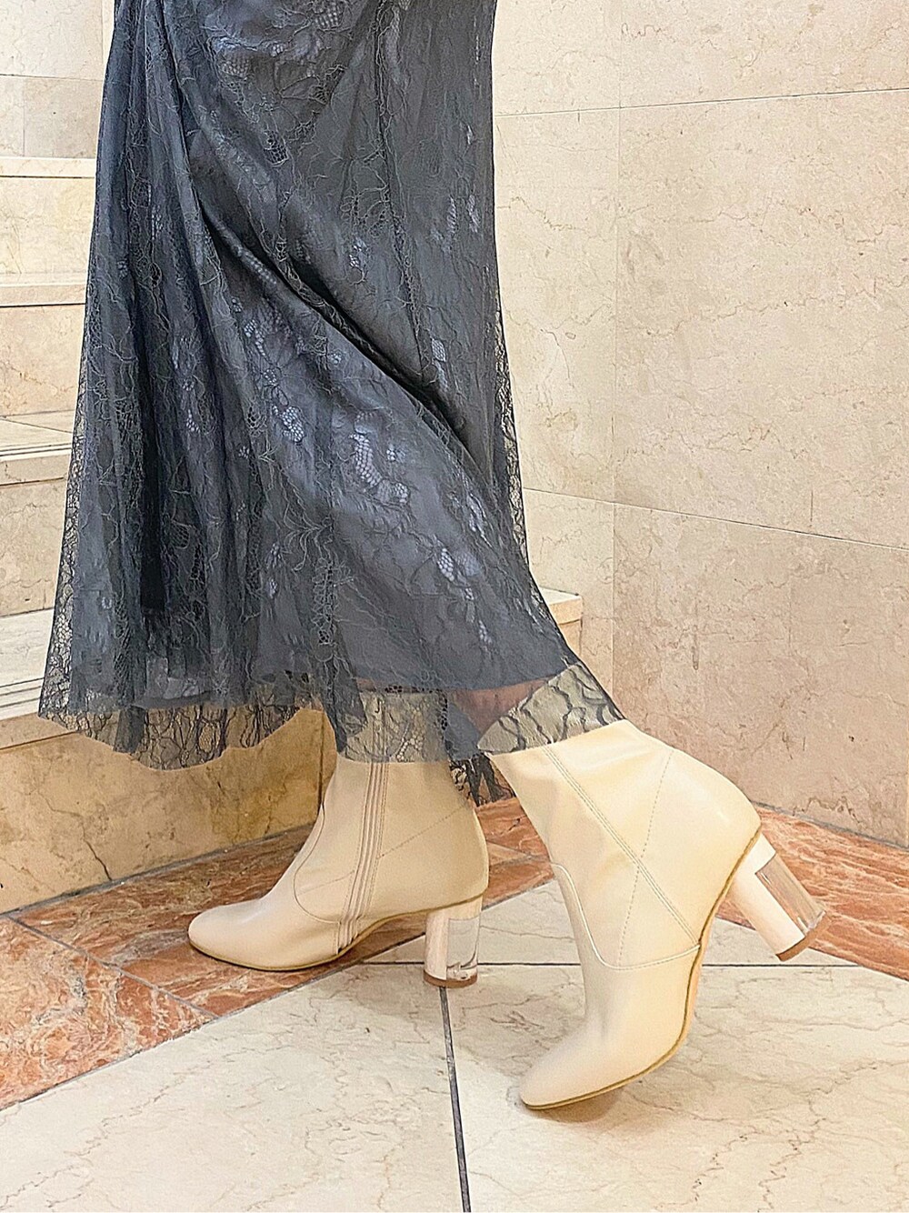 ホワイト系のブーツ、その他のイヤリングを着用したレディースの冬コーディネートの5枚目の写真