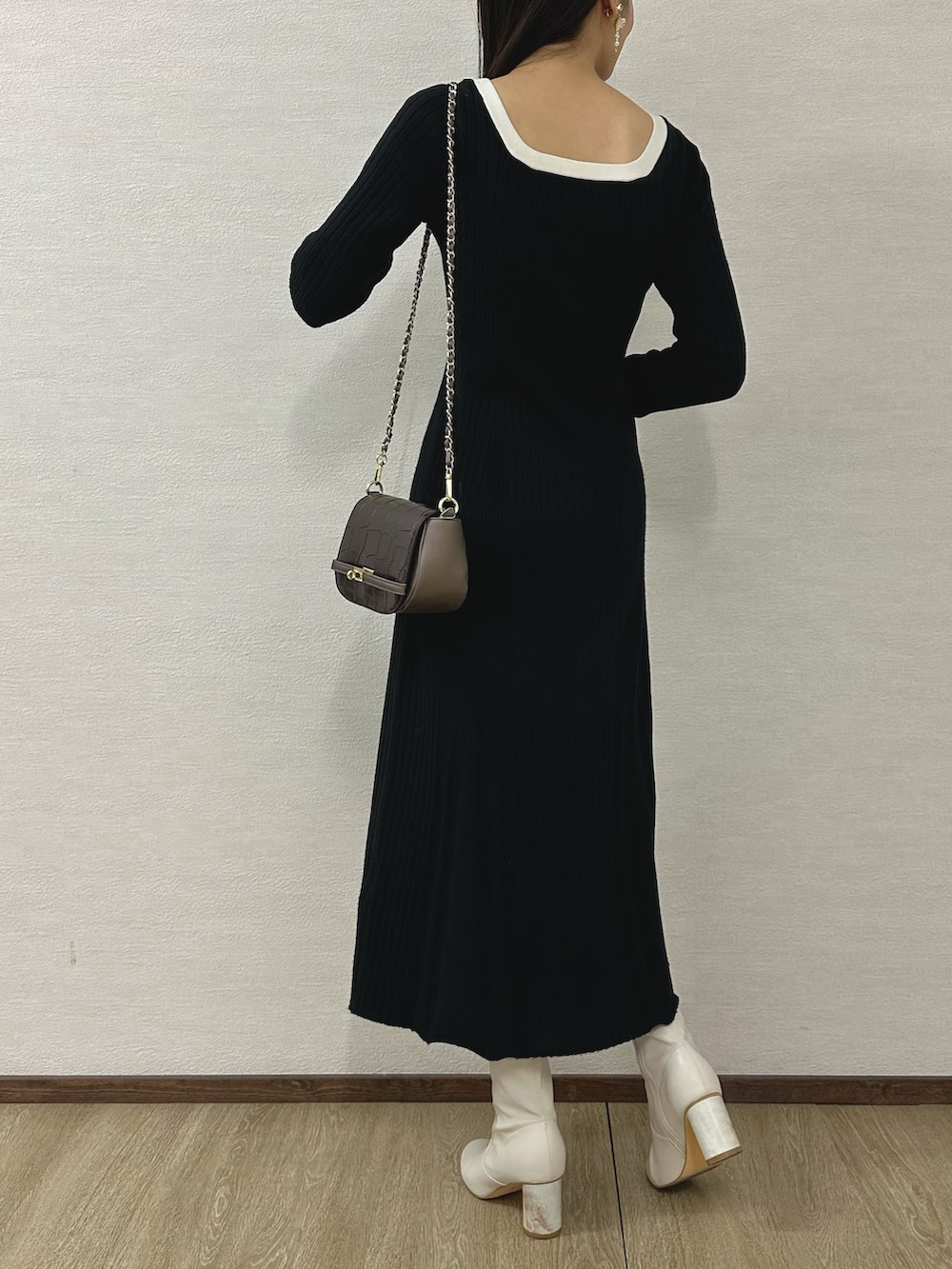 ホワイト系のブーツ、ブラウン系のハンドバッグ、ブラック系のワンピースを着用したレディースの秋コーディネートの3枚目の写真