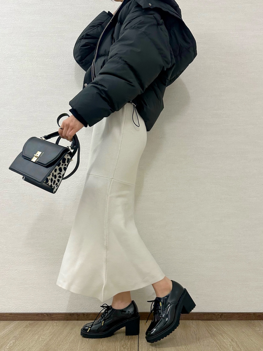 ブラック系のローファー、ホワイト系のワンピース、ブラック系のハンドバッグを着用したレディースの秋コーディネートの2枚目の写真