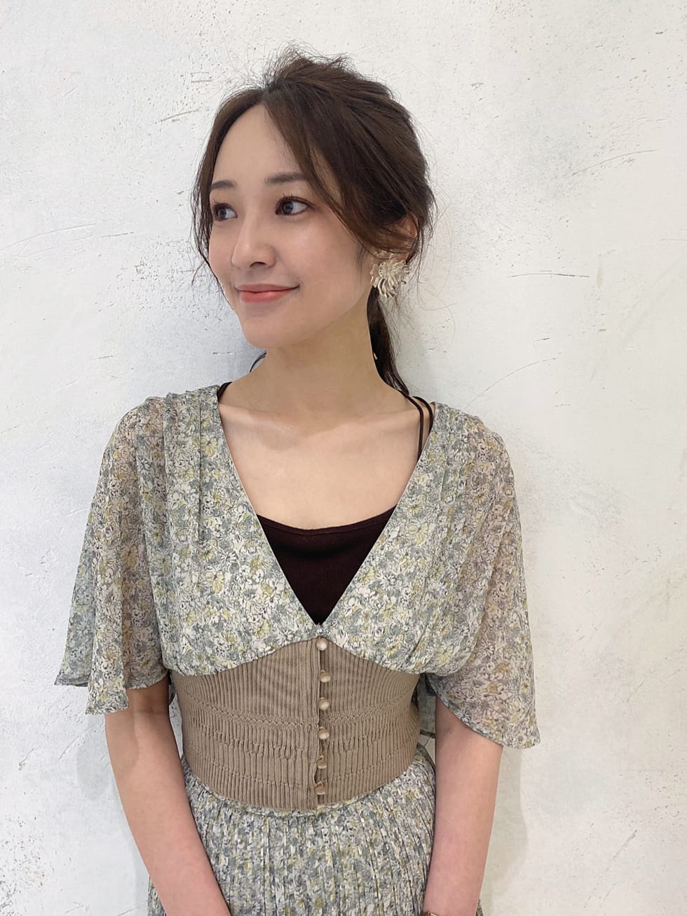 グリーン系のシャツ/ブラウス、ベージュ系のクラッチバッグ、グリーン系のスカートを着用したレディースの夏コーディネートの4枚目の写真