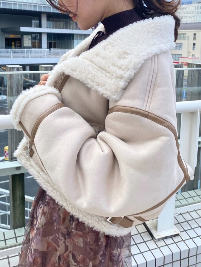 ベージュ系のブーツ、ベージュ系のムートンコート、ブラウン系のニット/セーターを着用したレディースの秋コーディネートの8枚目の写真