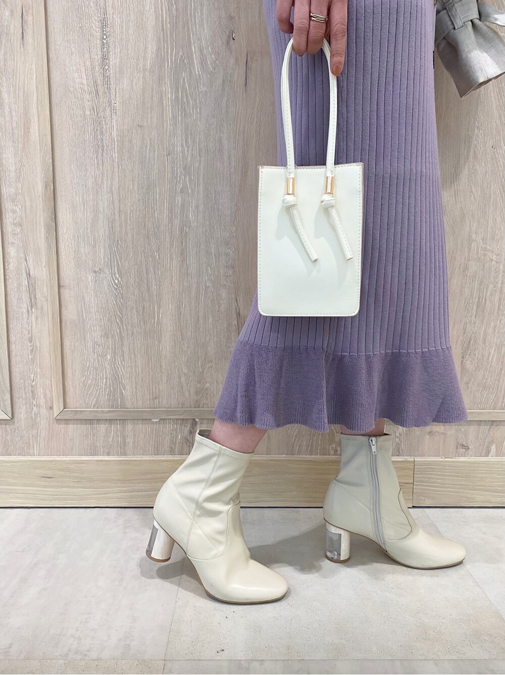 パープル系のワンピース、ホワイト系のブーツ、ホワイト系のハンドバッグを着用したレディースの冬コーディネートの5枚目の写真