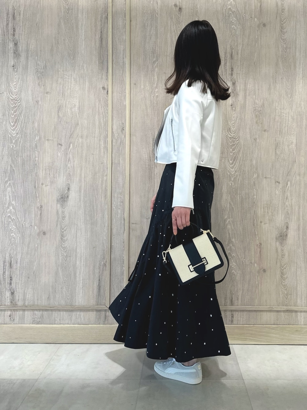 ピンク系のニット/セーター、ブラック系のハンドバッグ、その他のスカートを着用したレディースの春コーディネートの3枚目の写真