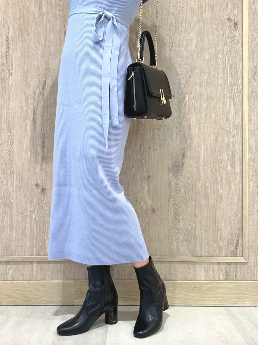 ブラック系のブーツ、ブルー系のワンピース、ブラック系のショルダーバッグを着用したレディースの冬コーディネートの7枚目の写真