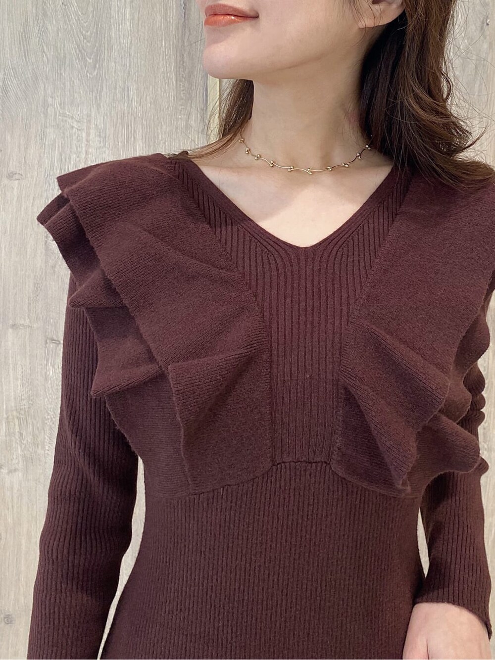 ブラウン系のワンピース、ベージュ系のブーツ、ゴールド系のネックレスを着用したレディースの冬コーディネートの5枚目の写真