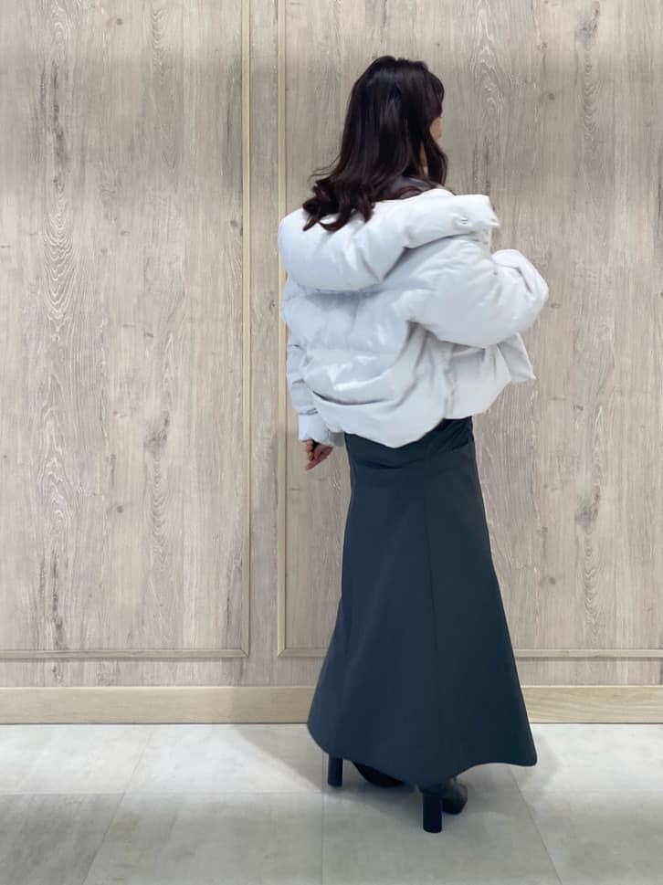 ホワイト系のダウンジャケット/コート、ブラック系のブーツ、パープル系のニット/セーターを着用したレディースの秋コーディネートの4枚目の写真