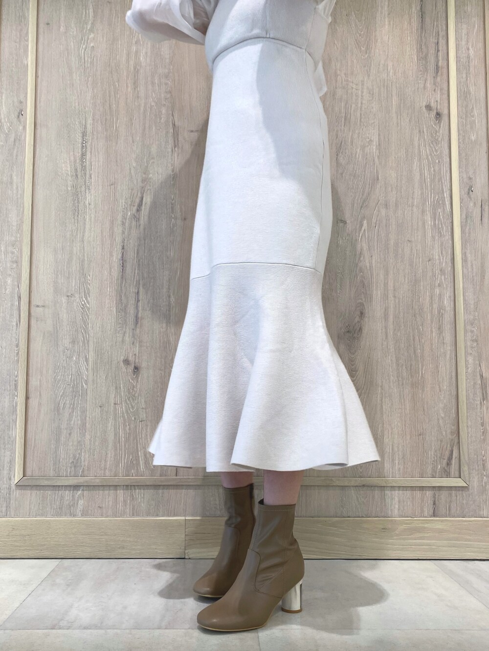 ベージュ系のブーツ、ホワイト系のワンピース、ホワイト系のチューブトップを着用したレディースの冬コーディネートの9枚目の写真