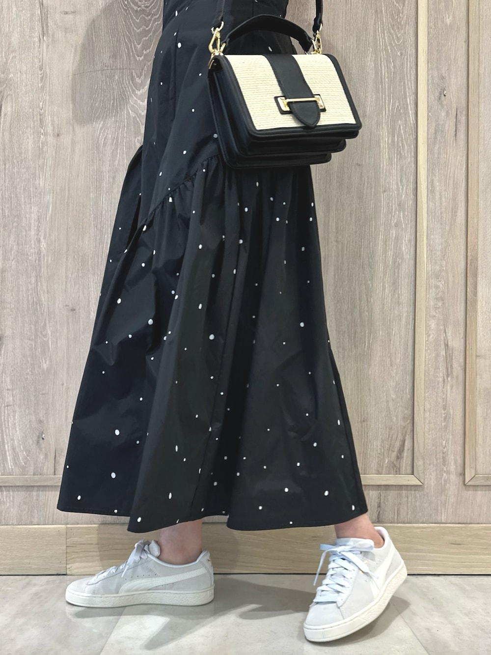 ピンク系のニット/セーター、ブラック系のハンドバッグ、その他のスカートを着用したレディースの春コーディネートの8枚目の写真