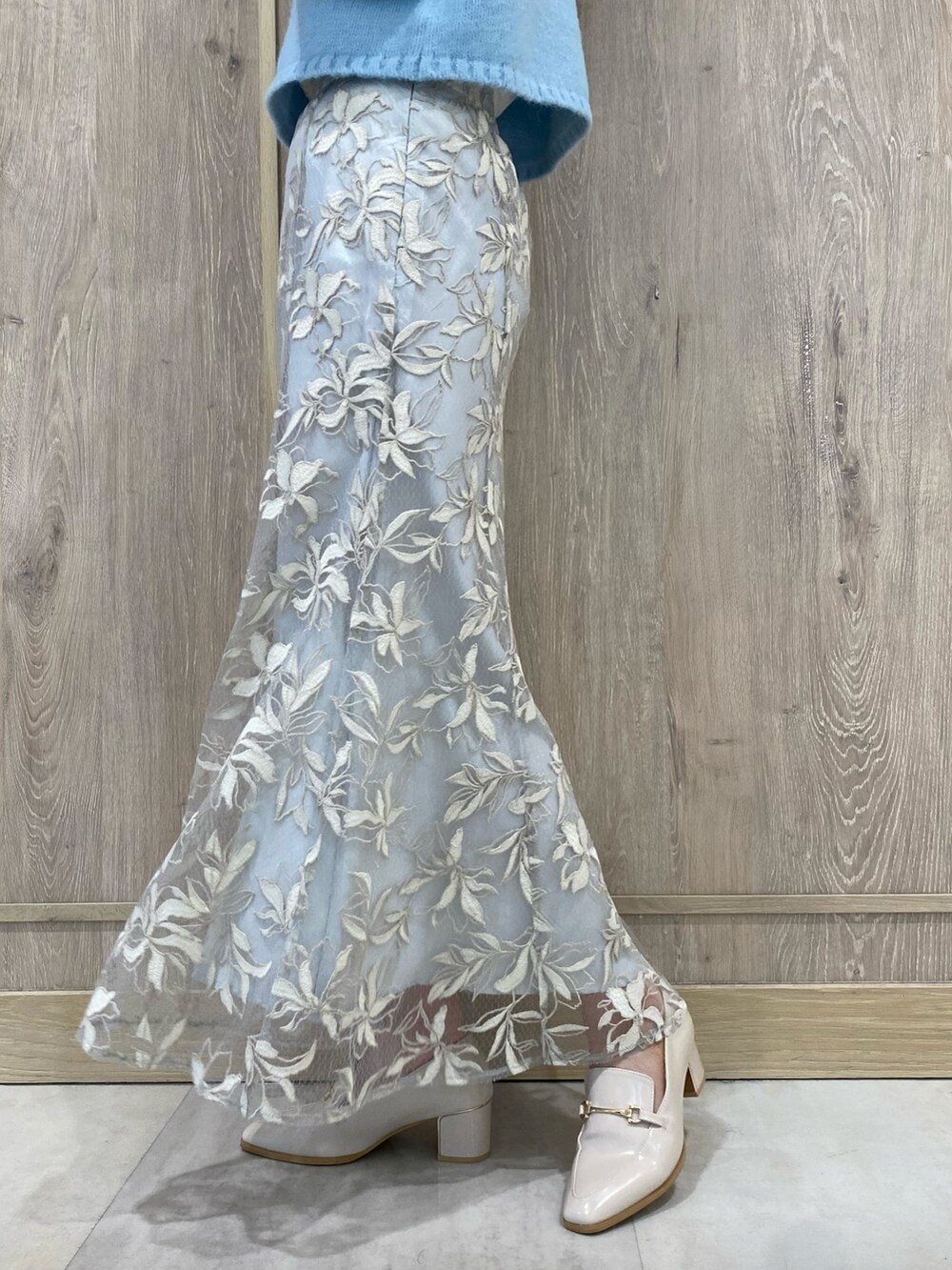 ブルー系のニット/セーター、ブルー系のスカート、ホワイト系のローファーを着用したレディースの秋コーディネートの7枚目の写真