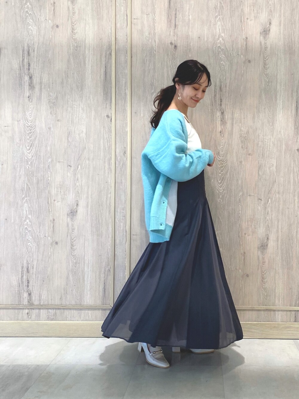 ホワイト系のローファー、グレー系のスカート、グリーン系のカーディガン/ボレロを着用したレディースの冬コーディネートの3枚目の写真