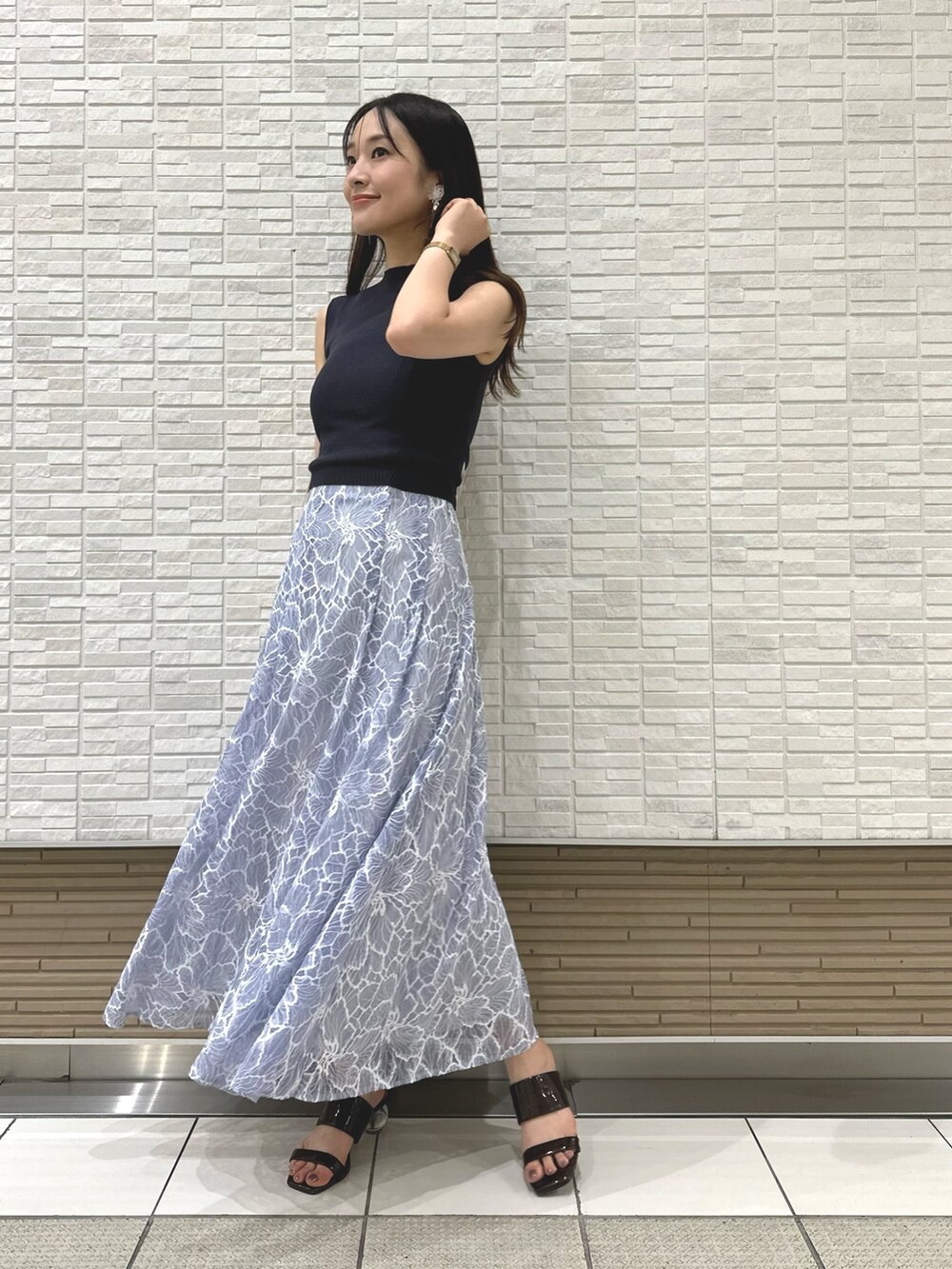 ブラック系のチューブトップ、ブルー系のスカート、ブラウン系のサンダルを着用したレディースの夏コーディネートの3枚目の写真