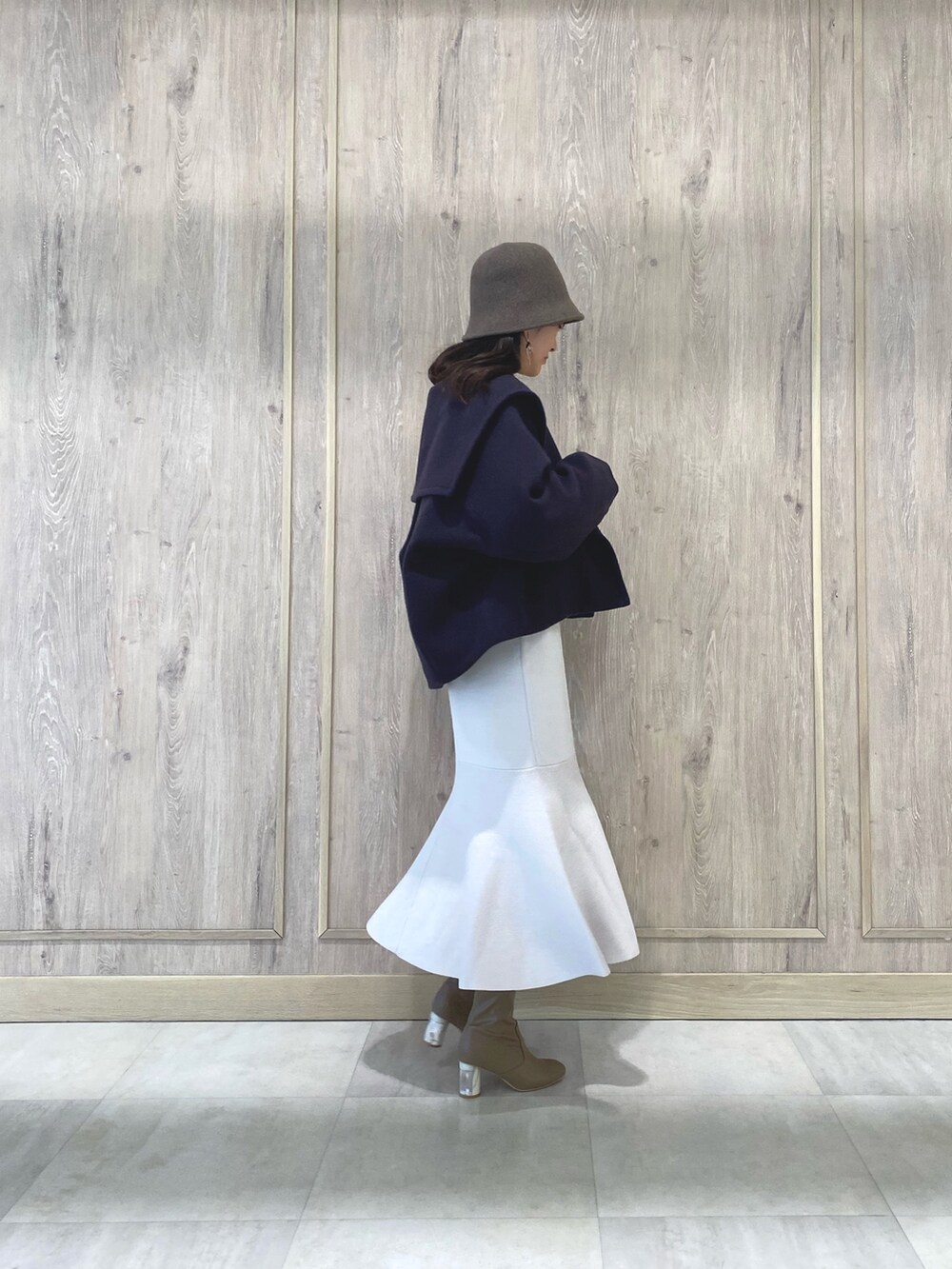 ベージュ系のブーツ、パープル系のその他アウター、ホワイト系のキャミソールを着用したレディースの冬コーディネートの3枚目の写真